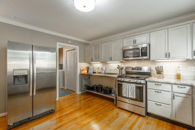 821 Ravine Rd, Signal Mountain, TN 37377 - kitchen featuring stainless steel appliances, ornamental molding, light wood-type flooring, and backsplash