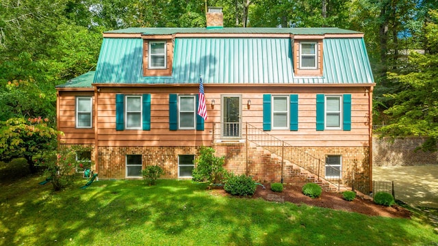 821 Ravine Rd, Signal Mountain, TN 37377 - view of front facade featuring metal roof, a chimney, a front yard, brick siding, and view of scattered trees