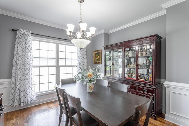 7531 Nightfall Cir, Ooltewah, TN 37363 - dining space featuring a chandelier, healthy amount of natural light, ornamental molding, a wainscoted wall, and wood finished floors