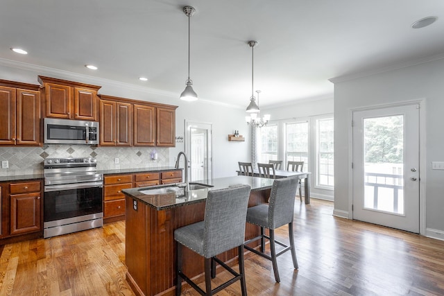 7531 Nightfall Cir, Ooltewah, TN 37363 - kitchen with appliances with stainless steel finishes, a sink, a kitchen bar, crown molding, and tasteful backsplash