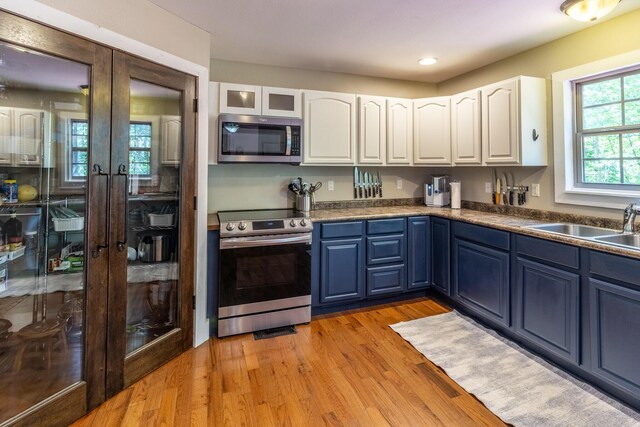 2217 Sr 399, Palmer, TN 37365 - kitchen with appliances with stainless steel finishes, french doors, blue cabinetry, a sink, and white cabinets