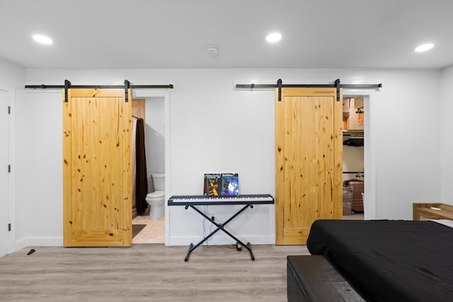 9503 Weidner Ln, Ooltewah, TN 37363 - bedroom featuring a barn door, wood finished floors, recessed lighting, ensuite bath, and baseboards