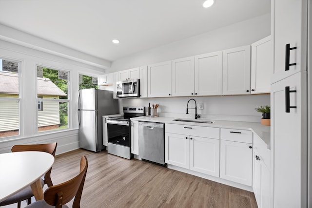 2806 N Chamberlain Ave, Chattanooga, TN 37406 - kitchen featuring stainless steel appliances, light countertops, light wood finished floors, white cabinets, and recessed lighting