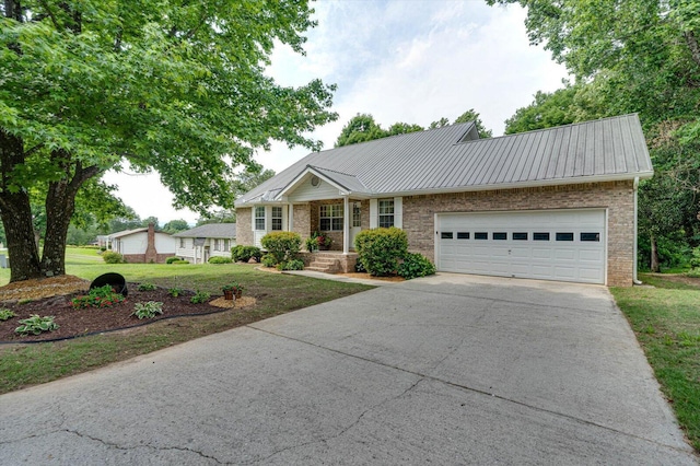 8719 Glenaire Dr, Chattanooga, TN 37416 - single story home with concrete driveway, brick siding, a garage, a front yard, and metal roof