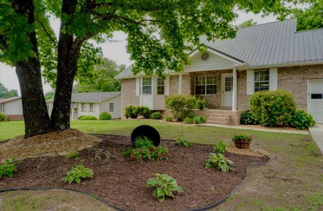 8719 Glenaire Dr, Chattanooga, TN 37416 - ranch-style home with an attached garage, brick siding, a metal roof, a front yard, and driveway