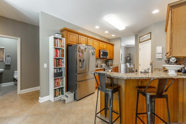 9923 Sims Harris Rd, Ooltewah, TN 37363 - kitchen featuring appliances with stainless steel finishes, tasteful backsplash, a peninsula, light stone countertops, and recessed lighting