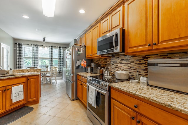 9923 Sims Harris Rd, Ooltewah, TN 37363 - kitchen with stainless steel appliances, light tile patterned flooring, brown cabinetry, decorative backsplash, and light stone countertops
