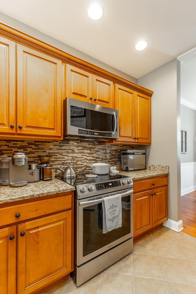 9923 Sims Harris Rd, Ooltewah, TN 37363 - kitchen featuring appliances with stainless steel finishes, backsplash, brown cabinets, baseboards, and recessed lighting