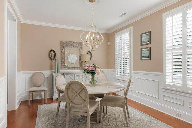 2027 Holden Farm Pl Unit 622, Ooltewah, TN 37363 - dining space with healthy amount of natural light, a chandelier, wood finished floors, ornamental molding, and a wainscoted wall