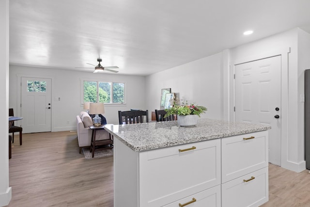 1795 Dowdy Rd, Cleveland, TN 37323 - kitchen featuring light wood-style floors, a ceiling fan, a kitchen island, light stone countertops, and white cabinets