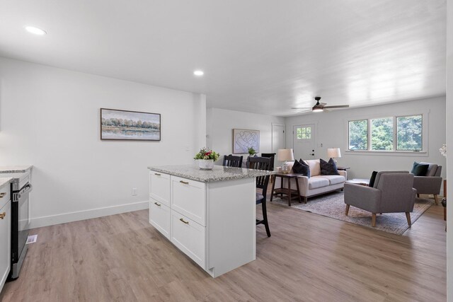 1795 Dowdy Rd, Cleveland, TN 37323 - kitchen featuring white cabinetry, a kitchen bar, light wood-style floors, a kitchen island, and open floor plan