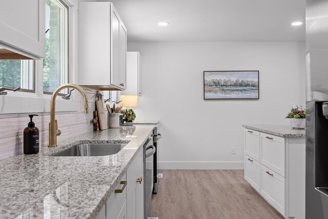 1795 Dowdy Rd, Cleveland, TN 37323 - kitchen with a sink, light wood finished floors, white cabinetry, baseboards, and light stone counters