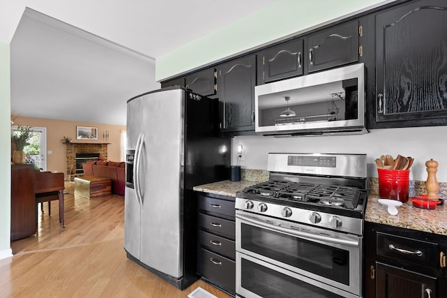 5726 Browntown Rd, Chattanooga, TN 37415 - kitchen featuring appliances with stainless steel finishes, light wood-type flooring, and dark cabinetry