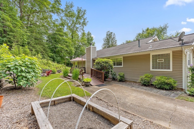 5726 Browntown Rd, Chattanooga, TN 37415 - rear view of house with a deck, roof with shingles, a vegetable garden, and a chimney