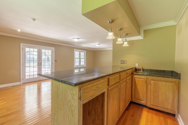7900 Ooltewah Georgetown Rd, Ooltewah, TN 37363 - kitchen with ornamental molding, a sink, light wood-type flooring, a peninsula, and dark stone countertops