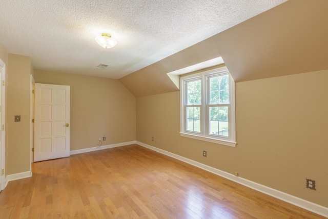 7900 Ooltewah Georgetown Rd, Ooltewah, TN 37363 - bonus room featuring light wood finished floors, a textured ceiling, lofted ceiling, and baseboards