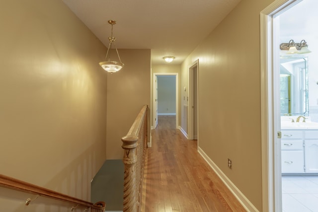 7900 Ooltewah Georgetown Rd, Ooltewah, TN 37363 - hallway with an upstairs landing, light wood-style floors, and baseboards