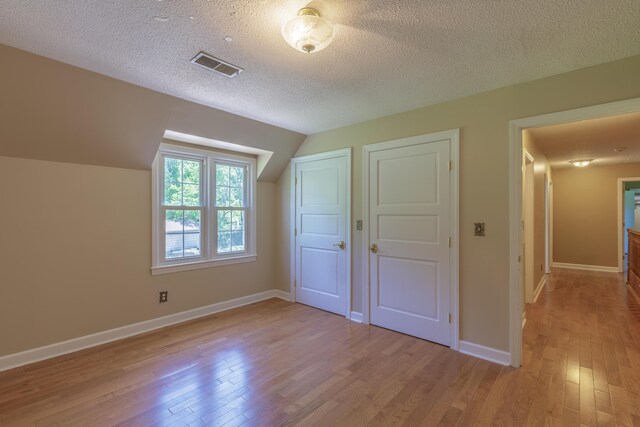 7900 Ooltewah Georgetown Rd, Ooltewah, TN 37363 - bonus room with light wood-style floors, lofted ceiling, a textured ceiling, and baseboards