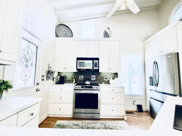 805 W Waugh St, Dalton, GA 30720 - kitchen featuring stainless steel appliances, white cabinets, beam ceiling, wood finished floors, and light countertops