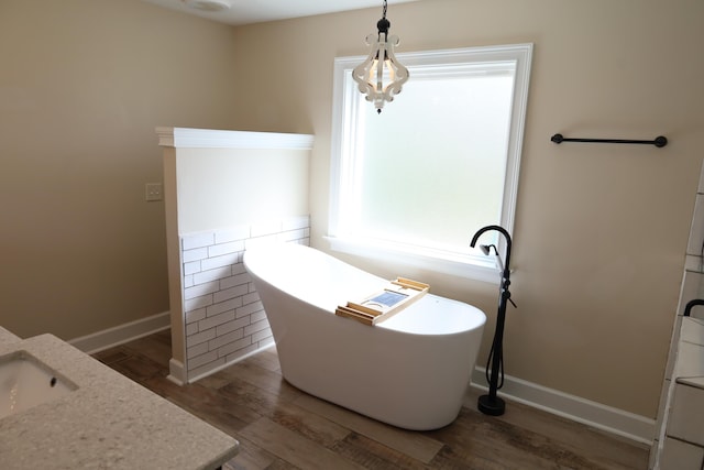 3239 Leona Dr, Rocky Face, GA 30740 - bathroom featuring wood finished floors, a freestanding bath, baseboards, and a sink