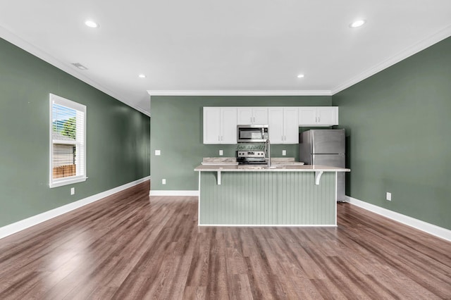 603 Browns Ferry Rd, Chattanooga, TN 37419 - kitchen with appliances with stainless steel finishes, ornamental molding, dark wood-style floors, an island with sink, and light countertops