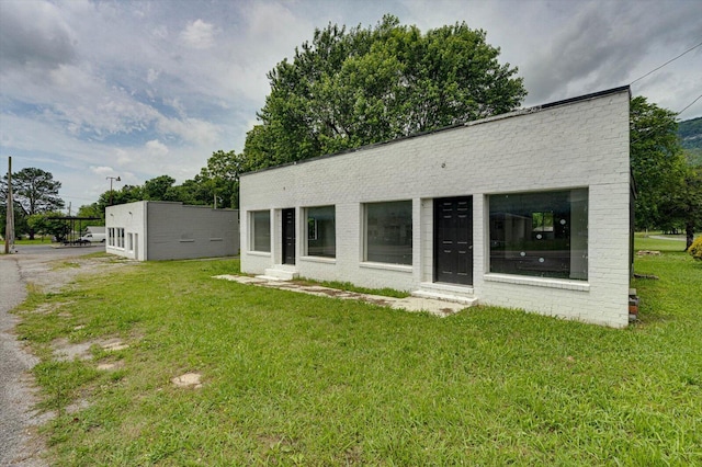 125 W Indiana Ave, Whitwell, TN 37397 - view of front of house with a front lawn, brick siding, and entry steps