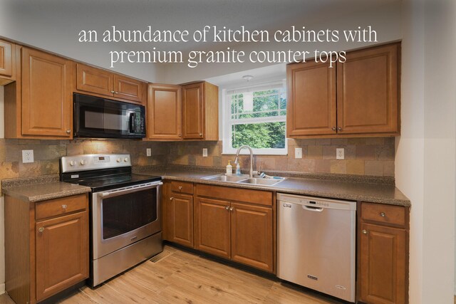7115 Elmbrook Ln, Harrison, TN 37341 - kitchen featuring appliances with stainless steel finishes, dark countertops, light wood-style floors, and decorative backsplash