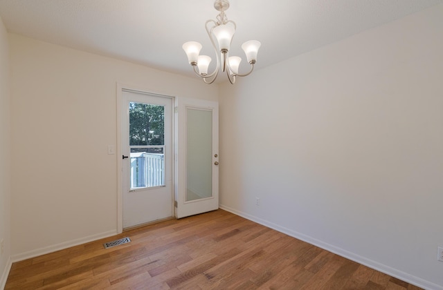 7115 Elmbrook Ln, Harrison, TN 37341 - empty room with light wood finished floors and a chandelier