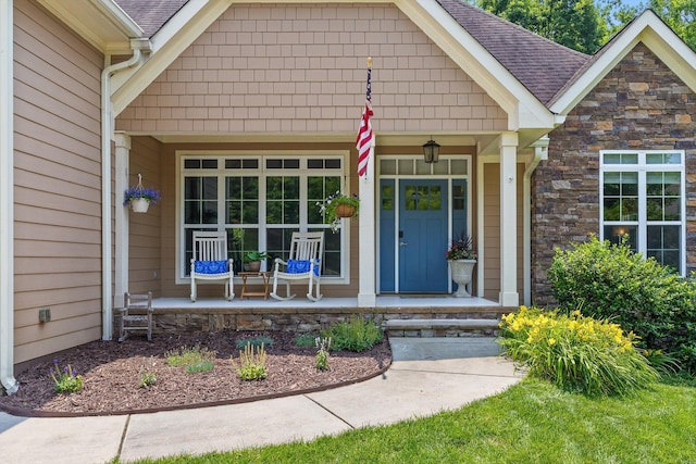 2904 Reflection Ln, Ooltewah, TN 37363 - view of exterior entry with a porch, stone siding, and roof with shingles