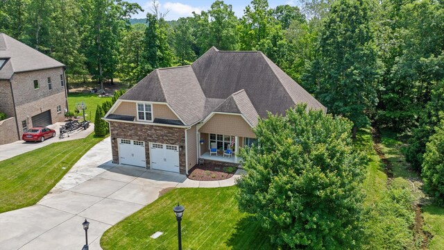 2904 Reflection Ln, Ooltewah, TN 37363 - view of front of home with driveway, a front yard, covered porch, a shingled roof, and stone siding