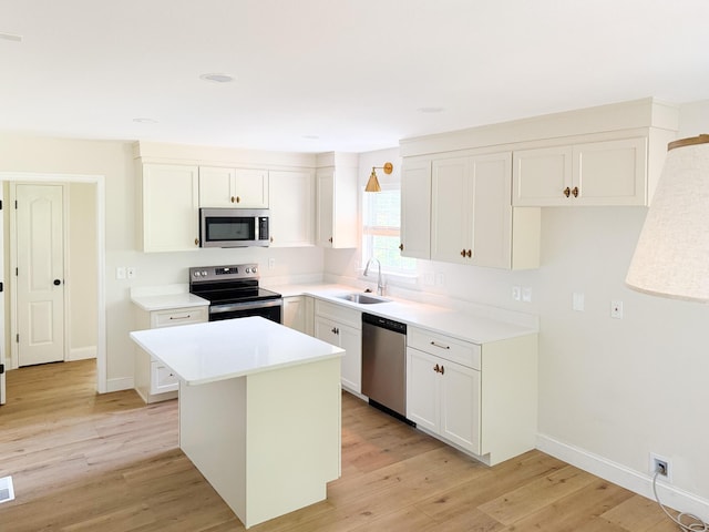 6527 Shallowmar Ln, Hixson, TN 37343 - kitchen with appliances with stainless steel finishes, a sink, light wood-type flooring, a center island, and baseboards