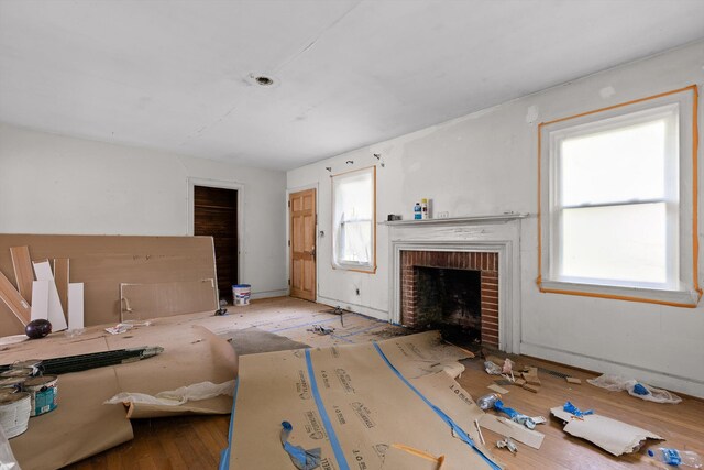 306 Pine Ridge Rd, Chattanooga, TN 37405 - unfurnished living room featuring healthy amount of natural light, a brick fireplace, and wood finished floors