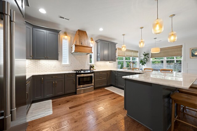 1355 Carrington Way, Chattanooga, TN 37405 - kitchen with appliances with stainless steel finishes, custom exhaust hood, a peninsula, light wood-style flooring, and gray cabinetry