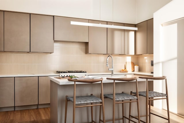 1800 S Watkins St Unit 22, Chattanooga, TN 37404 - kitchen featuring decorative backsplash, wood finished floors, light countertops, a center island with sink, and a kitchen breakfast bar