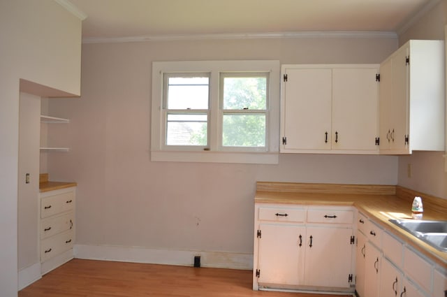 912 N Price St, Sweetwater, TN 37874 - kitchen with crown molding, light countertops, light wood finished floors, white cabinets, and baseboards
