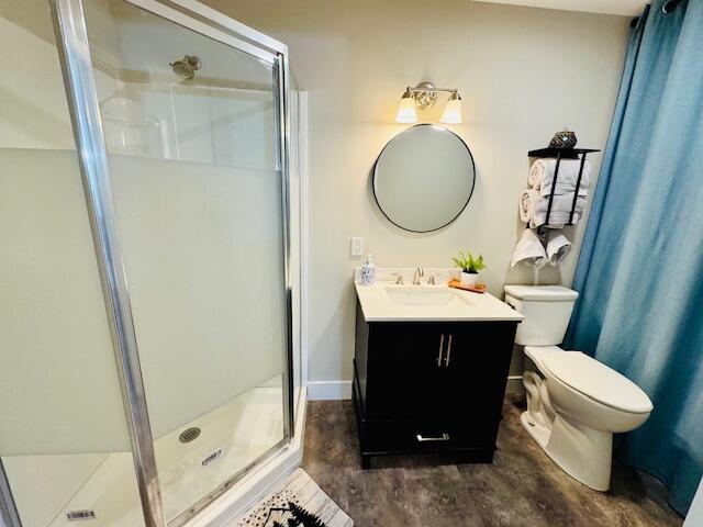 7015 Gamble Rd, Birchwood, TN 37308 - bathroom with concrete floors, a stall shower, vanity, toilet, and baseboards