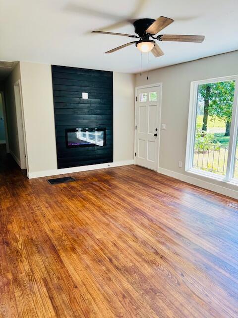7015 Gamble Rd, Birchwood, TN 37308 - unfurnished living room with a fireplace, wood finished floors, baseboards, and ceiling fan