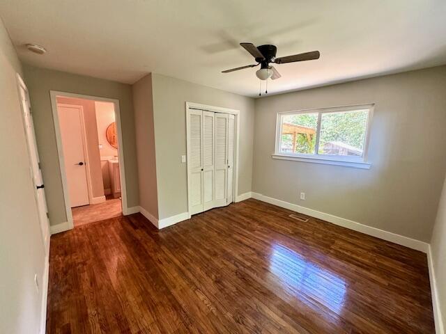 7015 Gamble Rd, Birchwood, TN 37308 - unfurnished bedroom with dark wood finished floors, baseboards, a closet, and a ceiling fan
