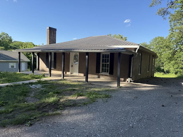 608 Bleeker St, Bridgeport, AL 35740 - view of front of home featuring a chimney, brick siding, and metal roof