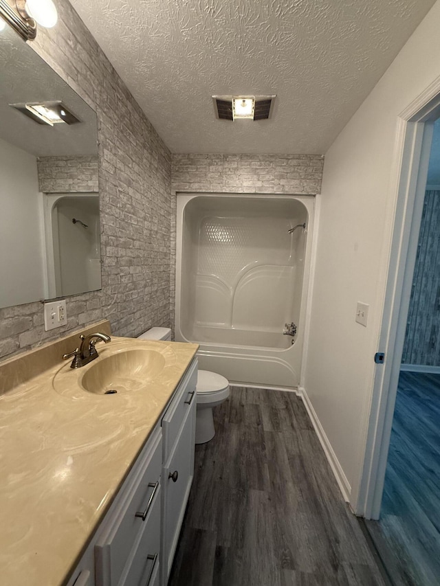 608 Bleeker St, Bridgeport, AL 35740 - full bathroom with vanity, toilet, wood finished floors, a textured ceiling, and baseboards