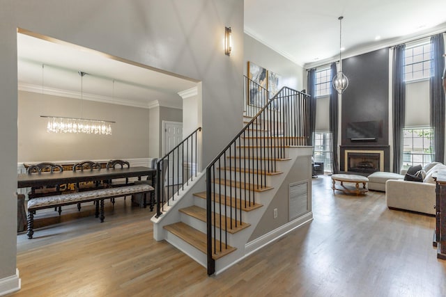 8102 Paces Ferry Xing, Chattanooga, TN 37421 - stairs with a chandelier, wood finished floors, a fireplace, crown molding, and plenty of natural light