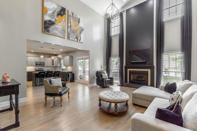 8102 Paces Ferry Xing, Chattanooga, TN 37421 - living room featuring a towering ceiling, crown molding, a chandelier, light wood-style floors, and a large fireplace