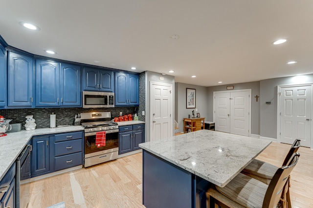 8614 Clearwood Rd, Chattanooga, TN 37421 - kitchen with stainless steel appliances, blue cabinetry, a kitchen breakfast bar, light wood-style flooring, and recessed lighting