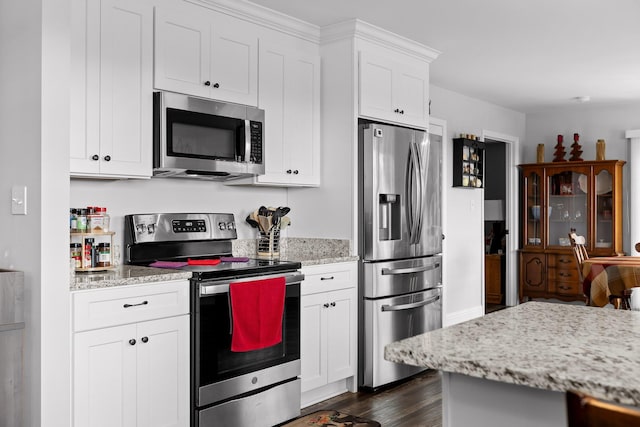 1008 Durgan Pl, Dalton, GA 30721 - kitchen featuring appliances with stainless steel finishes, white cabinetry, dark wood-type flooring, and light stone counters