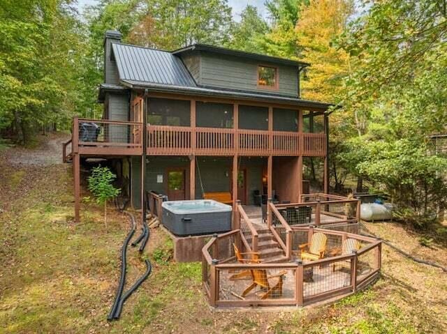 60 Clubhouse Ct, Ellijay, GA 30536 - rear view of house with a deck, a chimney, a sunroom, metal roof, and a hot tub