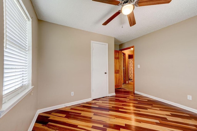 2049 Saunders Rd, Ringgold, GA 30736 - unfurnished bedroom featuring wood finished floors, baseboards, multiple windows, a ceiling fan, and a textured ceiling