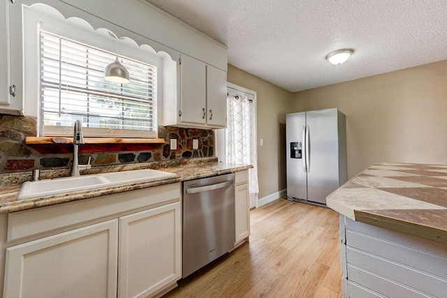 2049 Saunders Rd, Ringgold, GA 30736 - kitchen featuring appliances with stainless steel finishes, a sink, decorative backsplash, a textured ceiling, and light wood-style floors