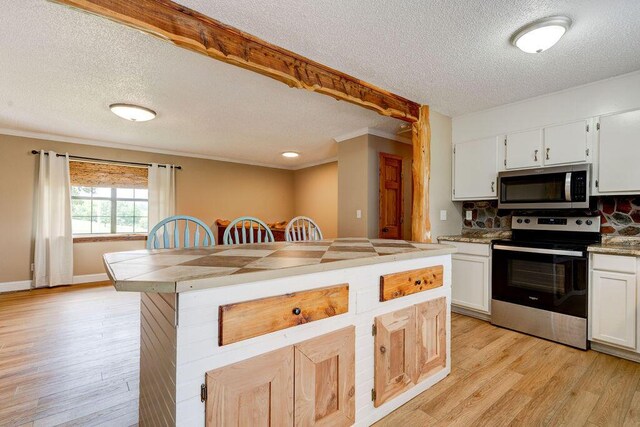 2049 Saunders Rd, Ringgold, GA 30736 - kitchen featuring appliances with stainless steel finishes, a textured ceiling, tasteful backsplash, light wood-style floors, and white cabinets