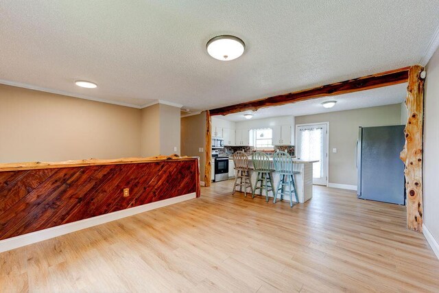 2049 Saunders Rd, Ringgold, GA 30736 - kitchen featuring appliances with stainless steel finishes, a textured ceiling, white cabinets, baseboards, and light wood-style floors
