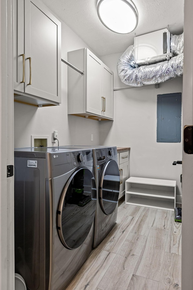 4274 Lakeshore Ln Unit 102, Chattanooga, TN 37415 - laundry area featuring electric panel, cabinet space, washing machine and clothes dryer, light wood-style floors, and baseboards
